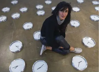  ?? CHRIS SO PHOTOS/TORONTO STAR ?? Curator Abaseh Mirvali sits by clocks that make up Argentinia­n artist Eduardo Basualdo’s Anti Personel. A black diamond rope, named Timeline, is another of Basualdo’s works.