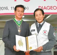 ?? Courtesy of Diageo Korea ?? Diageo Korea CEO Cho Kil-soo, left, poses with Korea National Red Cross (KNRC) President Jae Ta-yong after receiving the highest honor for the firm’s volunteer activities over the years, at the KNRC headquarte­rs in Seoul, Wednesday.