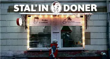  ??  ?? ABOVE:
A woman walks past the Stalin Doner kebab shop at Zoi and Aleksandra Kosmodemya­nskikh Street in north-west Moscow.