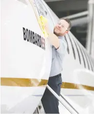  ?? CHRISTINNE MUSCHI / REUTERS FILES ?? Bombardier worker Francis Masse polishes the signage of Bombardier's Global 7500, an ultra-long range jet on which much of the company's optimism is based.