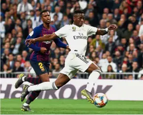  ??  ?? Still blunt: Real Madrid’s Vinicius Jr (right) dribbling past Nelson Semedo during the Spanish King’s Cup semi-final second-leg tie at the Bernabeu on Wednesday. — Reuters