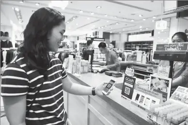  ?? XINHUA ?? A customer pays via the GCash payment system, a local version of Alibaba’s Alipay solution, at a store in Manila.