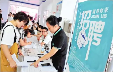  ??  ?? Job seekers pose queries at a job fair in Yichang, Hubei province in China.