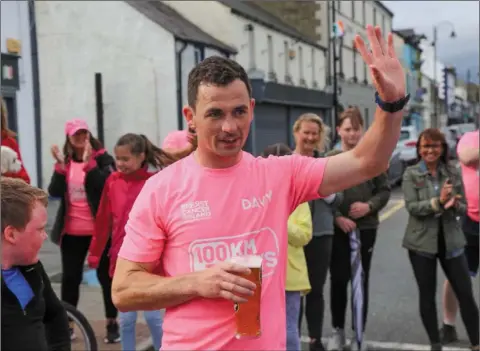  ??  ?? Jackie Agnew celebrates with a hard-earned pint after completing his 100km in one day.