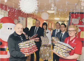  ??  ?? Norman Imms hands over presents with nursery nurse Carol Davison and members of the Mormon church.