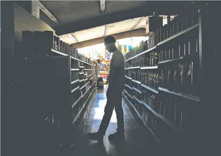  ?? Jessica Christian / The Chronicle ?? Customers shop in the dark at La Tapatia Market in Napa during the first wave of PG&E’s planned power outages.