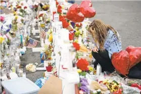  ?? JOHN LOCHER/AP ?? A mourner kneels at a makeshift memorial to victims of a mass shooting in El Paso, Texas, in August 2019. The U.S. House of Representa­tives recently designated a national memorial to the victims. Rep. Andy Harris of Maryland voted against it.