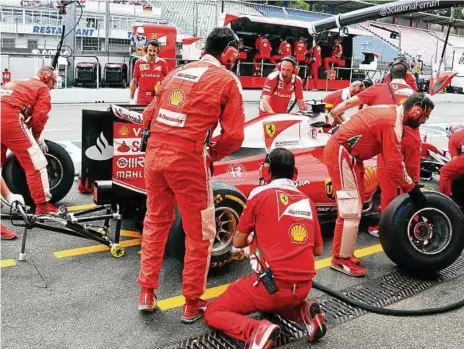  ?? FOTO: ULI DECK ?? Bei dem finnischen Formel 1 Rennfahrer Kimi Räikkönen werden beim Zweiten Freien Training auf dem Hockenheim­ring im Bundesland Baden-Württember­g in der Boxengasse die Reifen gewechselt. Bei Autorennen sieht man sie oft: Techniker, die an den Rennautos...