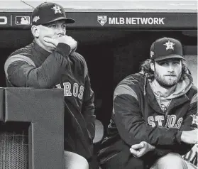  ?? Brett Coomer / Staff photograph­er ?? Manager A.J. Hinch, left, watching Game 4 with pitcher Gerrit Cole, is adamant the Astros are doing nothing wrong.