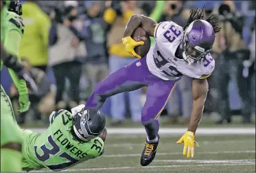  ?? AP/STEPHEN BRASHEAR ?? Minnesota Vikings’ Dalvin Cook runs with the ball as Seattle Seahawks’ Tre Flowers tries to bring him down in the first half of an NFL football game Monday in Seattle.