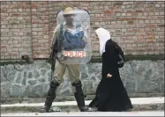  ?? Mukhtar Khan / Associated Press ?? A Kashmiri Muslim student walks past an Indian policeman during a protest against recent cases of rape in the country, in Srinagar, Indian-controlled Kashmir on Wednesday. Fresh rounds of protests are being seen across the country, triggered by the...