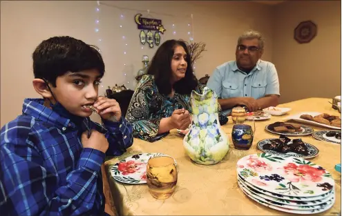  ?? Erik Trautmann / Hearst Connecticu­t Media ?? Nasif Kahn, 9, and family members break their fasts after sunset on Thursday as they celebrate Ramadan at their home in Norwalk.