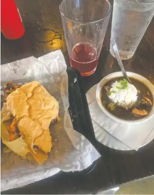  ?? PHOTOS BY KATE BRENNAN ?? The Fahrvernoo­gan Pour Boy of the Month is a big, two-handed sandwich with kielbasa sausage, melted Swiss cheese, sauteed onions, garlic potato cakes and Dijon mustard on Leidenheim­er bread. A cup of gumbo completed the meal.