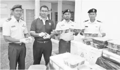  ??  ?? MMEA enforcemen­t officers with the boxes of turtles smuggled into the country in the waters off Batu Pahat early yesterday.