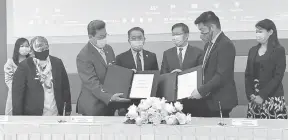  ??  ?? TERMETERAI: Abdul Aziz (empat kiri) bersama Dominic Su ( tiga kanan) menyaksika­n pertukaran dokumen antara Abdul Hadi (tiga kiri) dan Nicholas Wong (dua kanan) pada majlis tersebut.