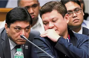  ??  ?? Private conversati­on: Paolo (right) speaking to his lawyer during the Senate hearing in Pasay, Manila. — Reuters