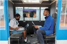  ?? ?? Students working on their laptops to link to the screen of a
solar-powered train.