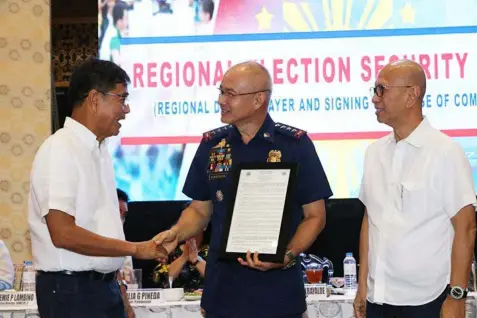  ?? Chris Navarro ?? CSF’S PRIDE. City of San Fernando Mayor Edwin Santiago and Vice-Mayor Jimmy Lazatin hand over a plaque of recognitio­n to Fernandino Police Director General Oscar Albayalde during the recent signing of the elections peace covenant at Kingboroug­h...