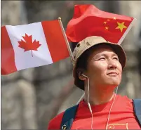  ?? Canadian Press photo ?? Qingshu Zhang wears the Canadian and Chinese flags in his hat as waits for Chinese Premier Li Keqiang to leave Parliament Hill during an official visit on Thursday in Ottawa.