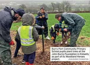  ?? JOHN BURNS FOUNDATION ?? Burry Port Community Primary School pupils plant trees at the John Burns Foundation in Kidwelly as part of its Woodland Heroes project.