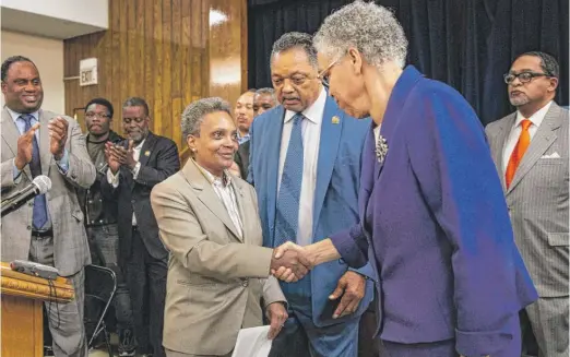  ?? ASHLEE REZIN/SUN-TIMES ?? Then-Mayor-elect Lori Lightfoot (left) shakes hands with former mayoral candidate Toni Preckwinkl­e, the Cook County Board president, as the Rev. Jesse Jackson and others look on during a press conference at Rainbow PUSH on April 3, the morning after election day.