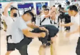  ?? The Associated Press Video ?? In this image taken from a video by The Stand News, white-shirted men attack a man dressed in black shirt at a subway station in Hong Kong on Sunday. The attack brought accusation­s of collusion between police and criminal gangs.