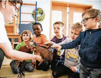  ??  ?? Wilma Oesterwind lässt die Kinder die Tiere auch streicheln. Luise war ruhiger als der Hahn.