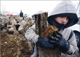  ?? LM OTERO — THE ASSOCIATED PRESS ?? Gilbert Rocha helps collect firewood to burn for warmth from a wood heap opened to the public Wednesday in Dallas.