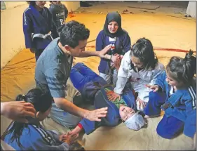  ??  ?? Hussaini helps Rana Rasuli after she fainted during a training session.