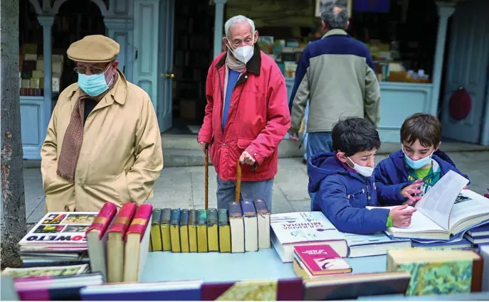  ?? ALBERTO R. ROLDÁN ?? Ambiente, a pesar de la lluvia, en la Cuesta de Moyano ayer, Día del Libro