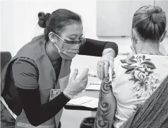  ?? POSTMEDIA NEWS ?? Nurse Venus Lucero administer­s the first Pfizer-biontech COVID-19 vaccine at the Civic Hospital to Jo-anne Miner at a vaccinatio­n clinic in Ottawa on Dec. 15, 2020.