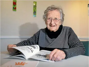  ??  ?? Maureen Fox, 88, looks over a year book from Kingswell High School, of which she was the first co-ed woman principal, in 1987. Fox is relocating to Palmerston North to be nearer her son, Aaron, and his family. ROBYN EDIE/STUFF