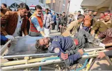  ?? Muhammad Sajjad/Associated Press ?? Workers carry an injured victim of an attack in Peshawar, Pakistan. A suicide bomber struck Monday inside a mosque, killing and wounding scores of worshipper­s, officials said.