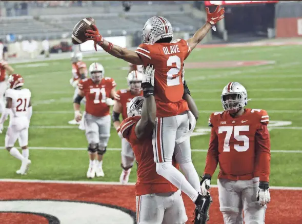  ?? ADAM CAIRNS/COLUMBUS DISPATCH ?? Tackle Nicholas Petit-frere lifts receiver Chris Olave into the air after his 33-yard touchdown catch in the fourth quarter.