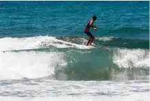  ??  ?? A picture shows 17year-old Syrian refugee Ali Kassem surfing off the shore of the town of Jiyeh, south of the Lebanese capital Beirut.