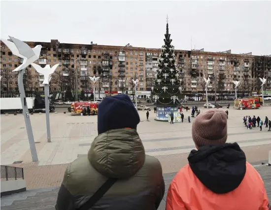  ?? BILD: ALEXEI ALEXANDROV ?? Mariupolbo­r vid ett torg med en julgran som pyntats för den ryskortodo­xa julen på torsdagen.