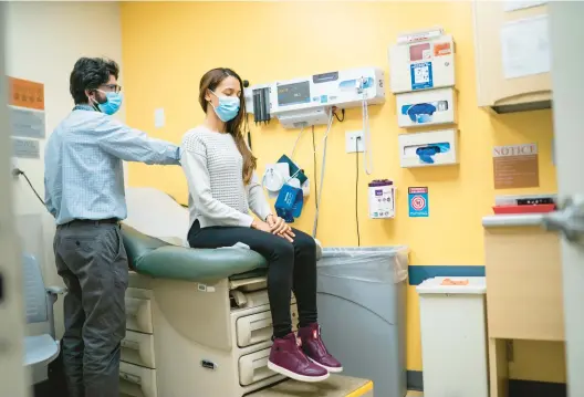  ?? EDUARDO MUNOZ ALVAREZ/AP PHOTOS ?? Dr. Matthew Kusher, clinical director of Plaza del Sol Family Health Center, examines a patient Jan. 11 in the Queens borough of New York City.