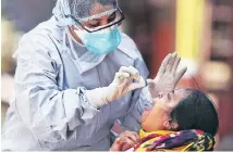  ?? PHOTO: REUTERS/FILE ?? A doctor wearing a protective gear tests a woman for coronaviru­s in Dharavi