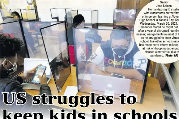  ?? (Photo: AP) ?? Senior Jose Solanohern­andez (right) studies with classmates on the first day of in-person learning at Wyandotte High School in Kansas City, Kansas, on Wednesday, March 30, 2021. Solanohern­andez feared he might not graduate after a year of disrupted learning left him missing assignment­s in most of his classes as he struggled to learn virtually. The school, like other schools nationwide, has made extra efforts to keep children at risk of dropping out engaged as classes went virtual due to the pandemic.