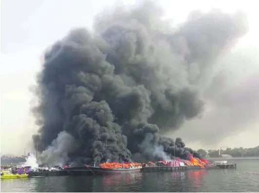  ?? Courtesy Government of Dubai Media Office ?? Three dhows, said to be carrying hundreds of thousands of dirhams worth of goods, burn on Dubai Creek.