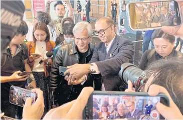  ?? AFP ?? Nvidia chief Jensen Huang (centre left) poses for photos before attending a press conference at Computex 2023 in Taipei yesterday.