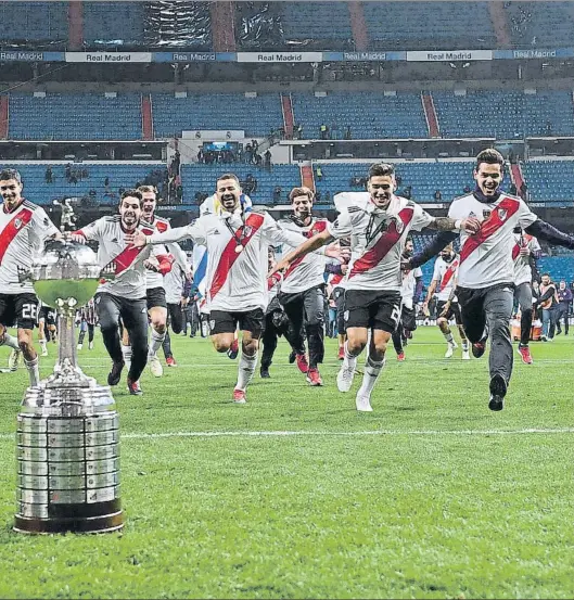  ?? FOTO: GETTY ?? Los jugadores de River Plate corren hacia el trofeo de la Copa Libertador­es que acaban de conquistar en el Santiago Bernabéu tras derrotar a Boca Juniors en la prórroga.