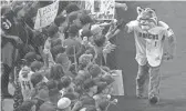  ?? CHERYL EVANS/THE REPUBLIC ?? Baxter, the Diamondbac­ks’ mascot, high-fives fans before the game. The team is marking its 20th anniversar­y this season.