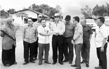  ??  ?? Julaihi (fifth left) inspects the damaged stretch of road. On his right is JKR Betong divisional engineer Mihan Jorai.