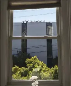  ?? KEVIN WOOD VIA AP ?? In this photo provided by Kevin Wood, UPS workers wave from the rooftop of a UPS package delivery warehouse where a shooting took place Wednesday in San Francisco. A UPS spokesman said several people were injured in the shooting at the facility and...