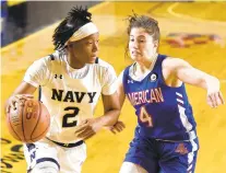  ?? PAUL W. GILLESPIE/CAPITAL GAZETTE ?? Navy junior Jennifer Coleman, pictured driving past American’s Emily Fisher on Jan. 16, has been named second-team All-Patriot League after averaging 17.1 points and 11.3 rebounds per game.