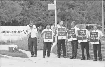  ?? Elías Valverde II/THE Dallas Morning NEWS/TNS ?? American Airlines pilots with the Allied Pilots Associatio­n stand along Trinity Boulevard during an informatio­nal picket in front of American Airlines Headquarte­rs in Fort Worth, Texas on Sept. 1, 2022.