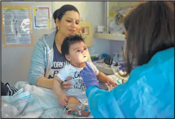  ?? Mark Mulligan / Houston Chronicle ?? Blanca Romero keeps a close eye on her son, 3-month-old Sebastian, as he is examined by Dr. Sarah Nicholas last month in Sebastian’s isolation room at Texas Children’s Hospital.