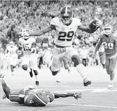  ?? Kevin C. Cox Getty Images ?? MINKAH FITZPATRIC­K of Alabama returns an intercepti­on for a touchdown as Brandon Powell of Florida defends in the first quarter of the Southeaste­rn Conference championsh­ip game. Alabama won, 54-16.