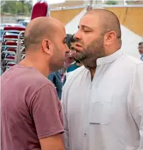  ?? — AFP ?? Zakaria Al Jawadah, right, the father of Mohammed Mohammed Al Jawawdeh, a 17-year-old Jordanian, who was killed on Sunday by an Israeli security guard, holds back his tears at a funeral tent in Amman on Monday.